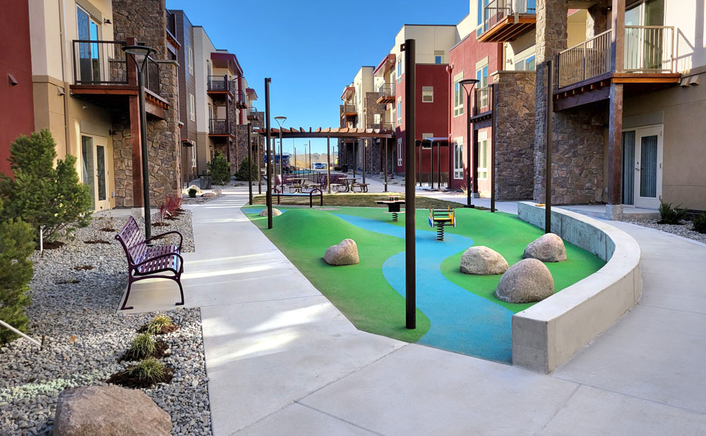 tot lot playground kid friendly courtyard landscape explore adventure garden whimsical natural play elements affordable housing apartment complex amenities